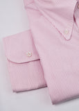 Folded pink and white striped shirt on a light gray background