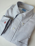 Folded blue and white striped shirt with a brand label on a light gray background