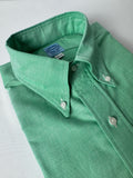 Green shirt with collar and buttons on a light gray background